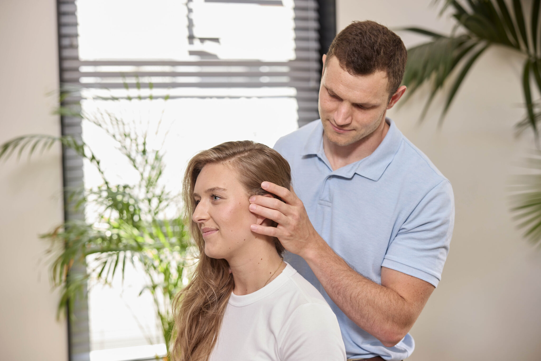 Chiropractor behandelt hoofd van vrouw met spanningshoofdpijn