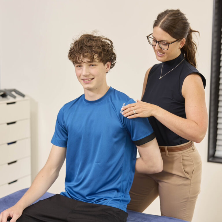 Chiropractor behandelt sporter aan schouder